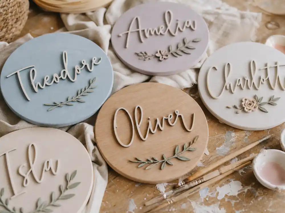Handcrafted wooden nursery name plaques on craft table — celebrity baby names unique and trending favor custom wall art over generic registry picks