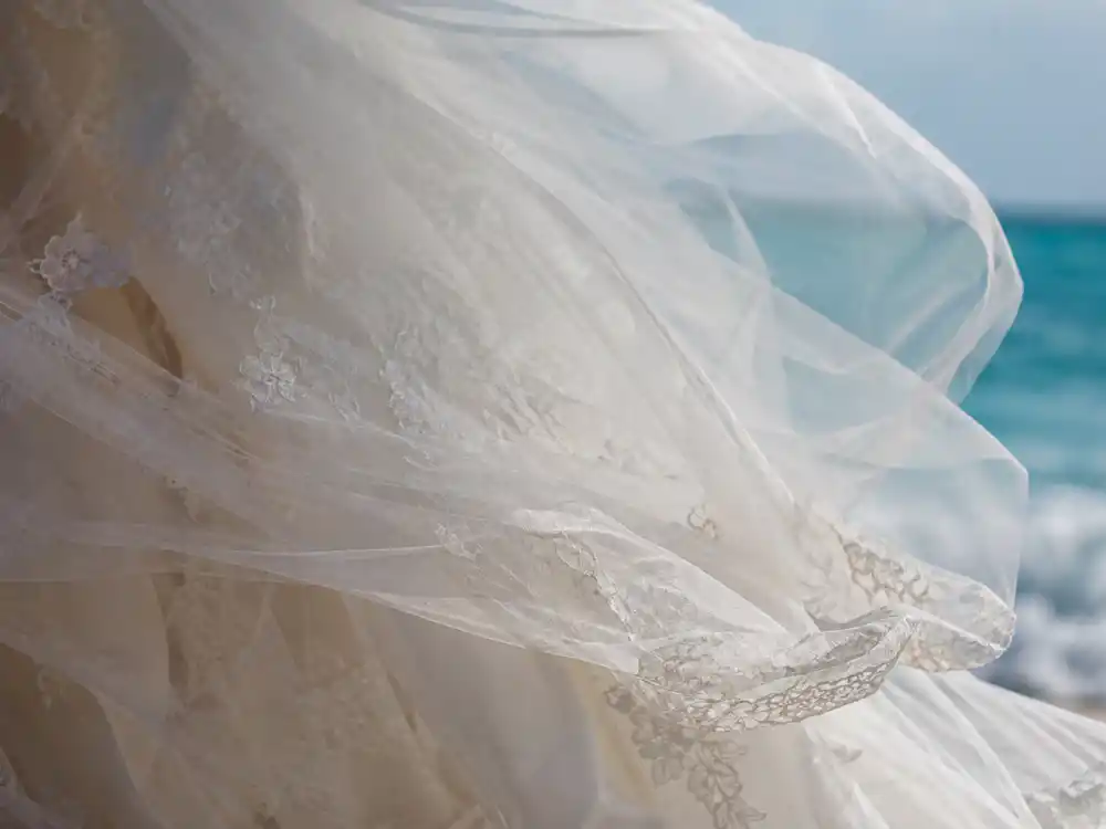Airy tulle and lace layers catching ocean breeze — fabric science at the heart of every credible celebrity beach wedding dress looks guide