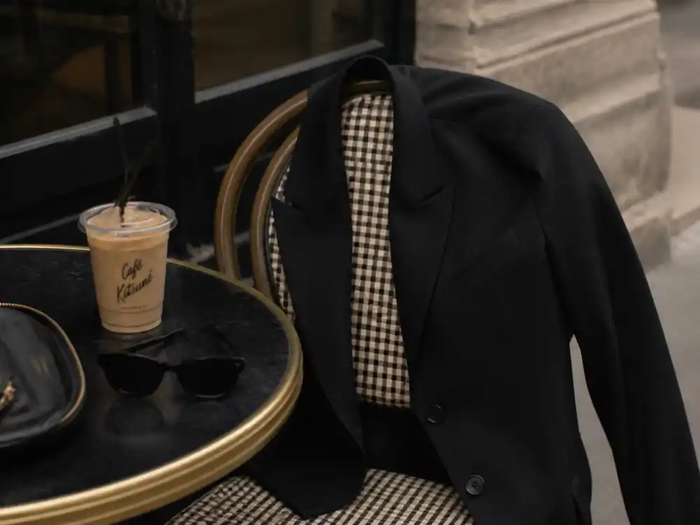 Oversized black blazer beside iced latte central to celebrity casual errands style 2026 tailored-meets-athleisure codes