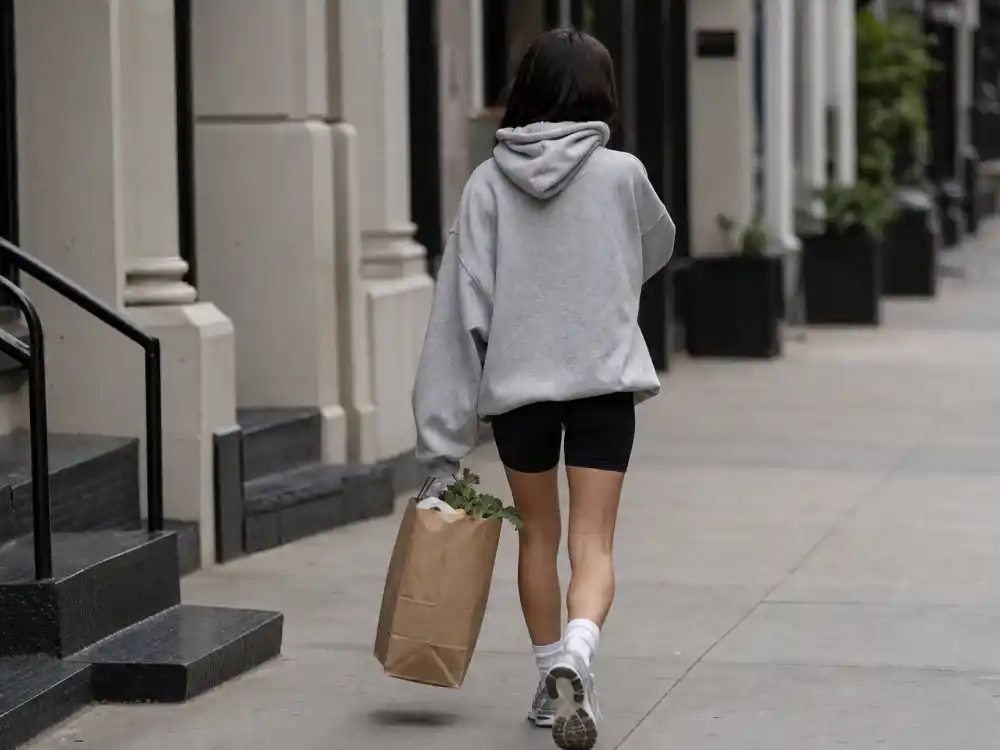 Oversized grey hoodie and biker shorts rotation within celebrity casual errands style 2026 athleisure grocery run dressing