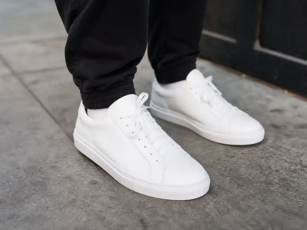 Pristine white leather sneakers with black joggers defining celebrity casual errands style 2026 elevated casual footwear