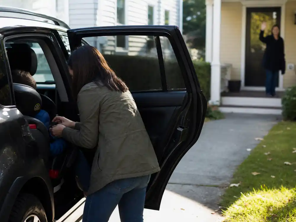 School morning car-seat handoff from behind for celebrity co-parenting success stories 2026 Hilary Duff blended co-parent lane editorial without identifiable faces