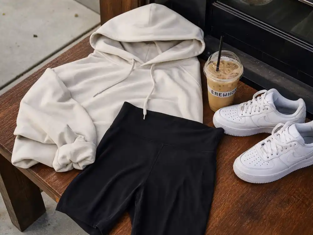 Oversized cream hoodie and bike shorts central to celebrity coffee run outfits street style athleisure uniform