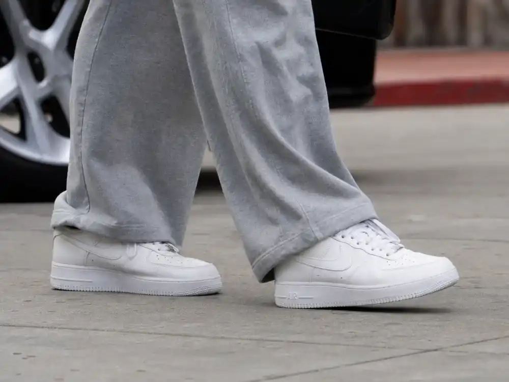 Clean white leather sneakers on pavement showing celebrity coffee run outfits street style footwear discipline
