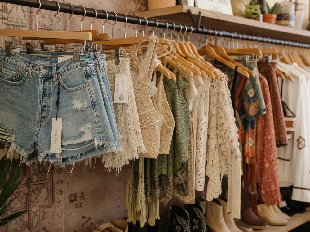 Distressed high-waisted denim shorts and crochet halter tops on boutique rack illustrating celebrity festival outfit guide women denim silhouette codes