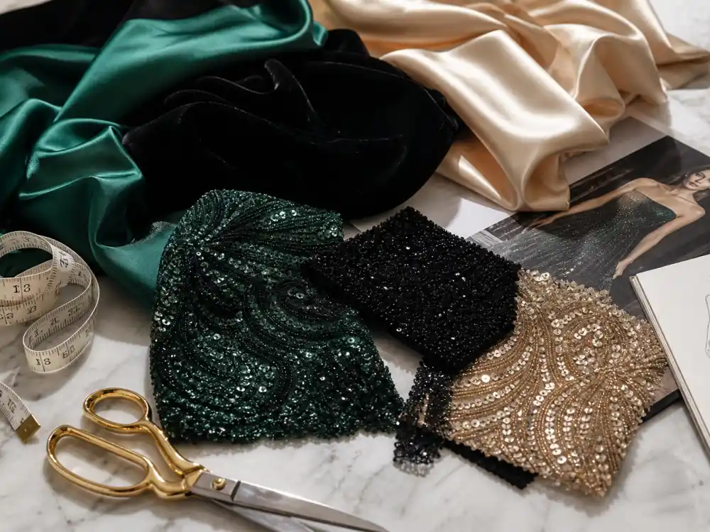 Luxury gala dress fabric swatches including emerald satin, black velvet, and champagne silk samples illustrating celebrity gala dress inspiration material choices for formal evening wear