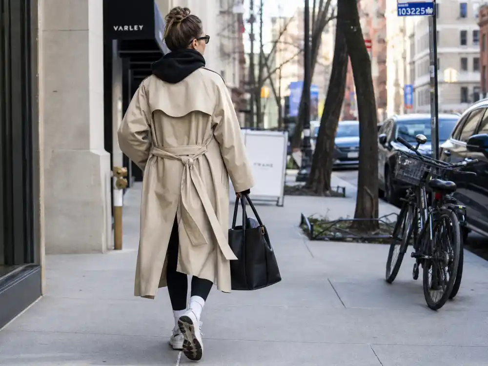 Beige belted trench over hoodie and leggings elevating celebrity gym to street style outfits for sidewalk polish