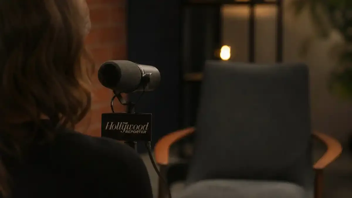 Celebrity kids rejecting nepo baby label — interview microphone from behind with anonymous reporter silhouette and Hollywood Reporter studio setup without identifiable faces
