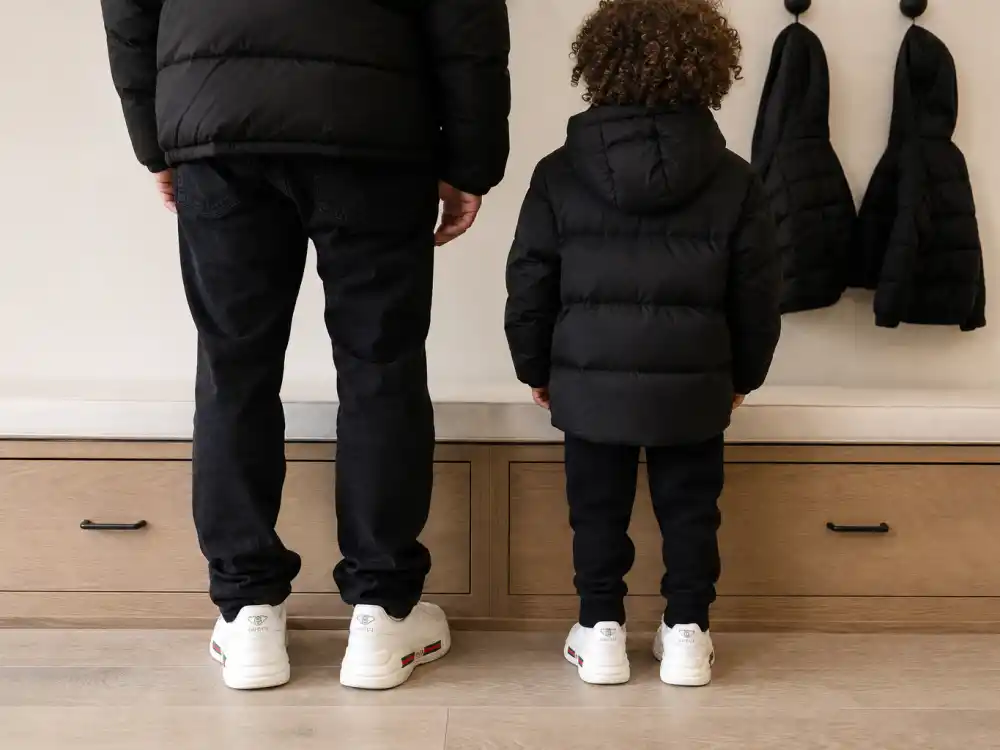 Matching adult and child white sneakers on mudroom bench for celebrity kids who look like their parents coordinated wardrobe mirror verified by Us Weekly