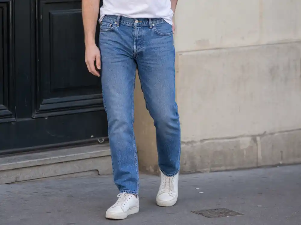 Close-up of classic straight-leg blue jeans with plain white t-shirt for celebrity normcore fashion trend denim styling detail