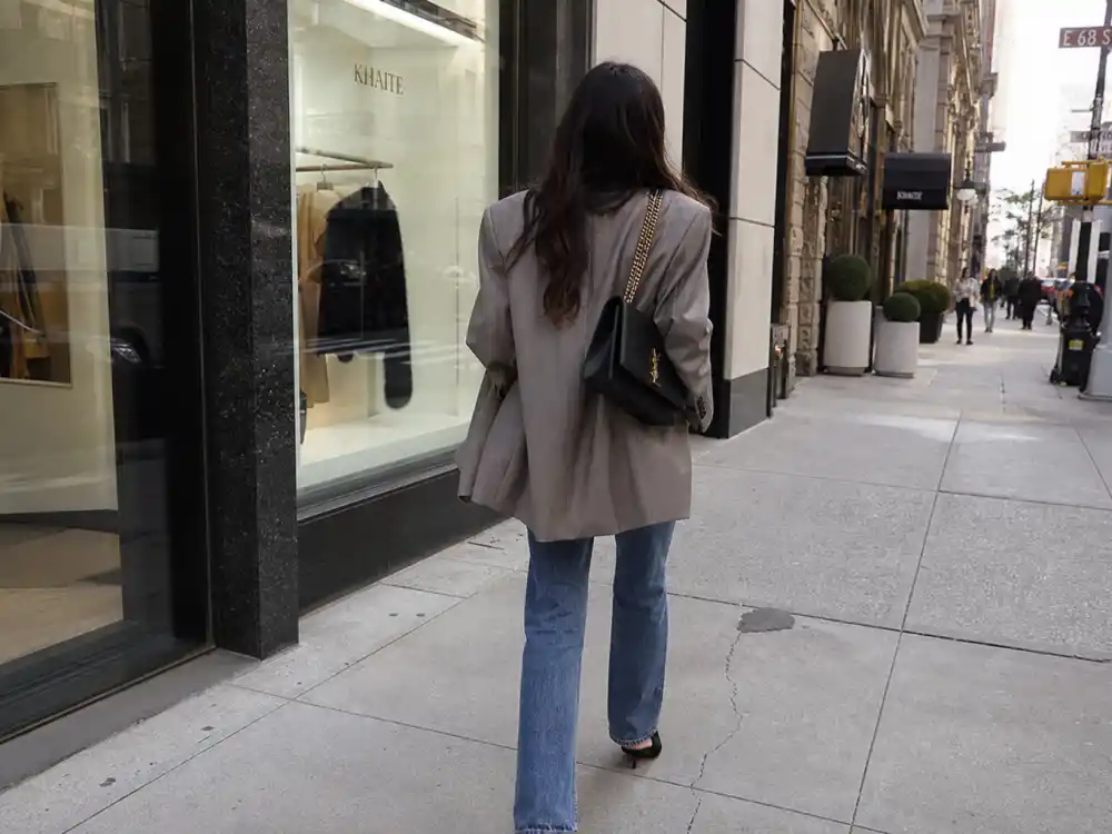 Anonymous woman from behind in oversized blazer and straight jeans on Manhattan sidewalk showing celebrity outfits off-duty street style inspiration