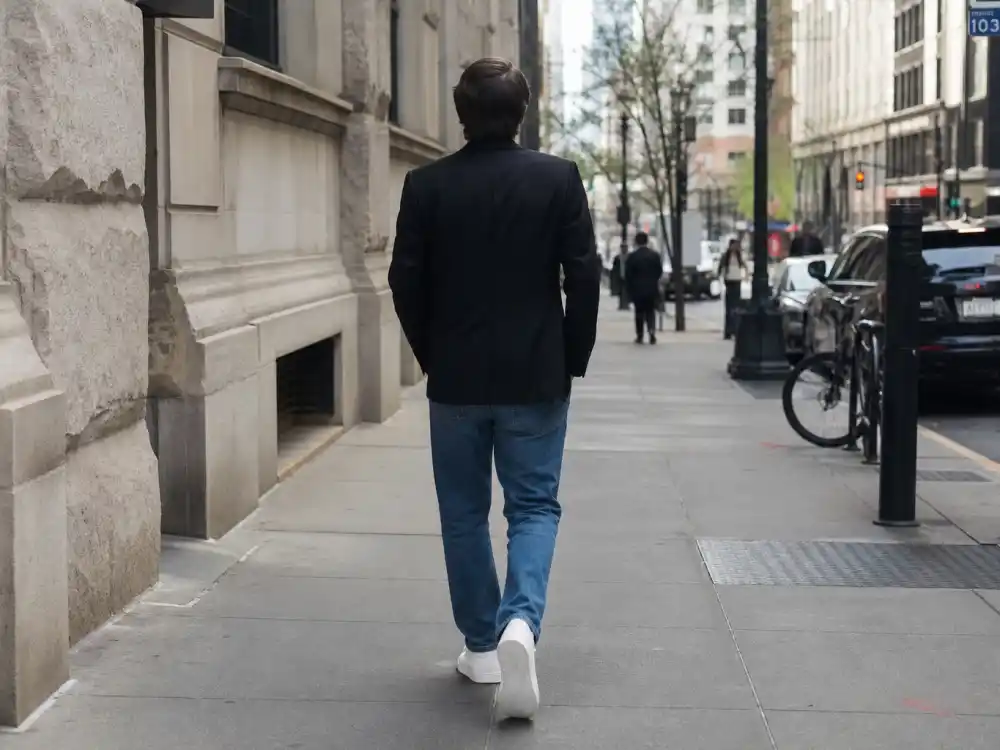 Tailored black blazer white tee straight jeans and clean sneakers elevating celebrity sneaker street style outfits polished off-duty dressing