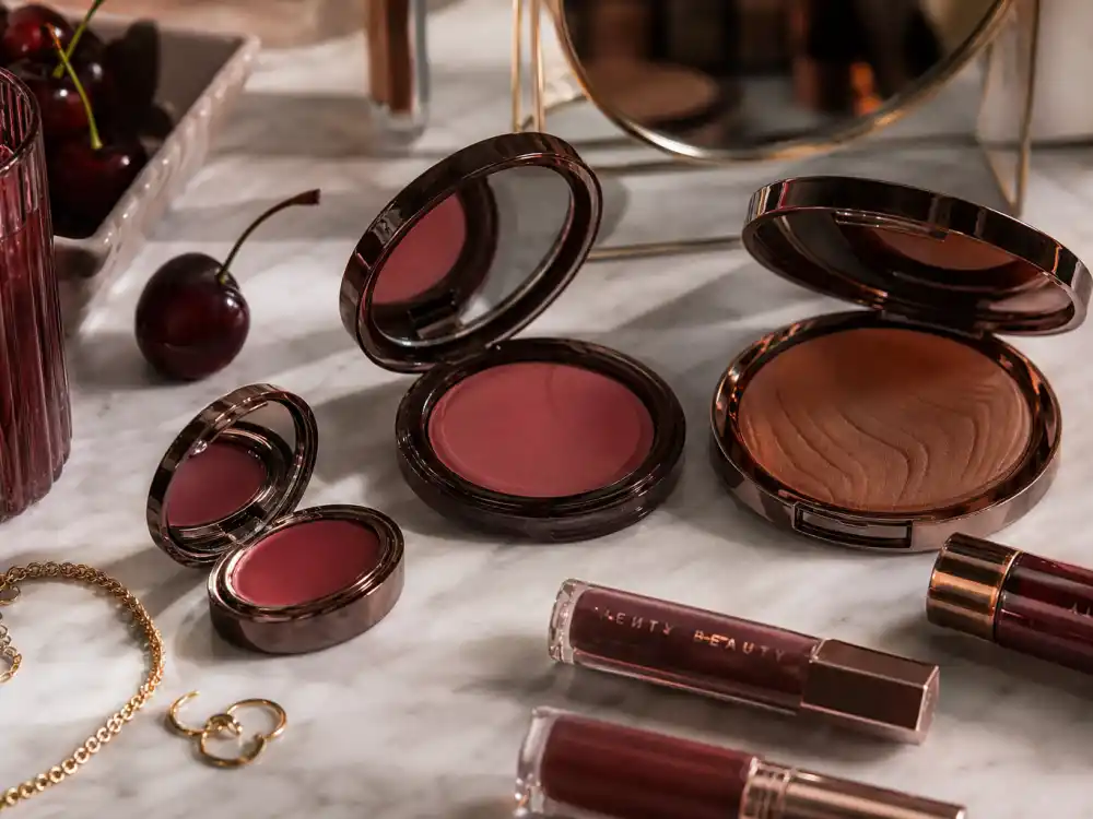 Marble beauty vanity with cherry cola blush compacts and warm red-brown bronzer illustrating cherry cola beauty celebrity trend product staging