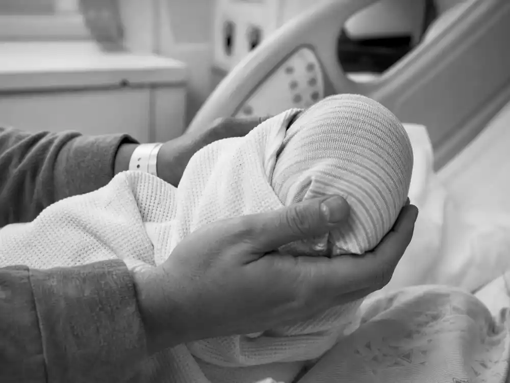 Hospital newborn hands cradle for Chrissy Teigen baby announcement surrogate guide — Esti Maxine Stephens born Jan 13 2023 via C-section Chrissy carried