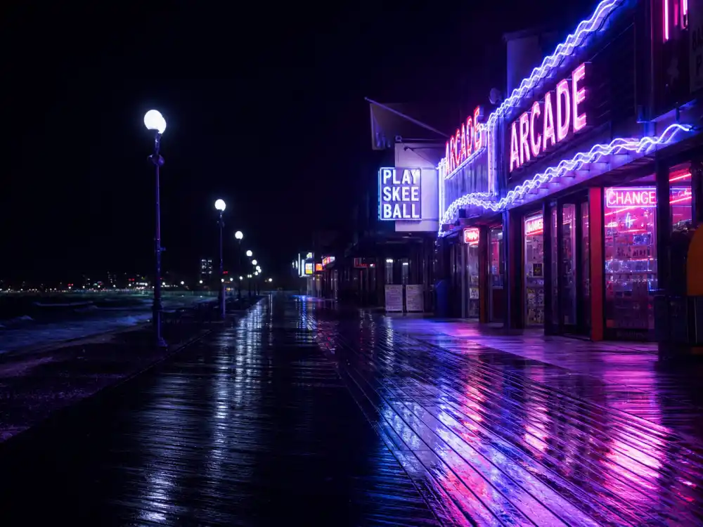 Neon-lit seaside boardwalk at night evoking Corey Feldman in The Lost Boys vampire cult classic