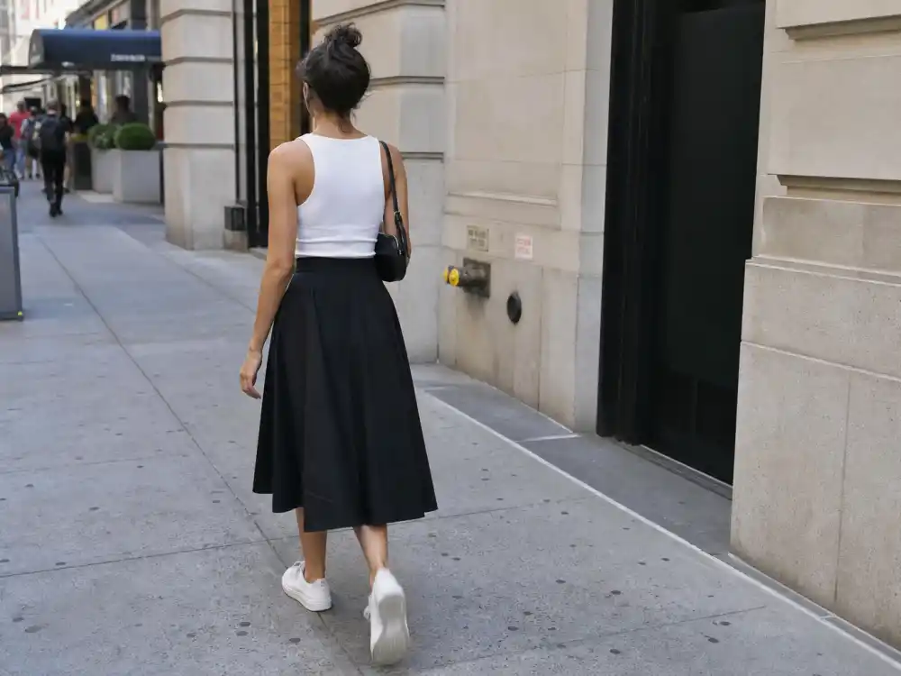 White ribbed tank and black mini skirt with sneakers central to Emily Ratajkowski street style outfits mini uniform