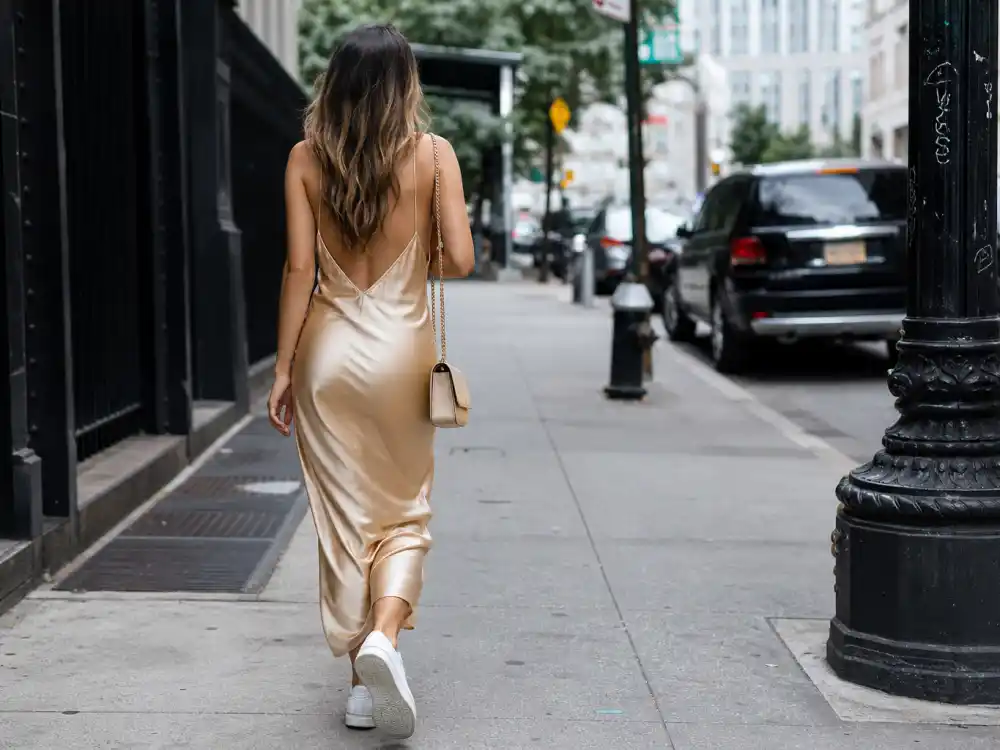 Champagne silk slip dress with white retro sneakers showing Emily Ratajkowski street style outfits high-low contrast