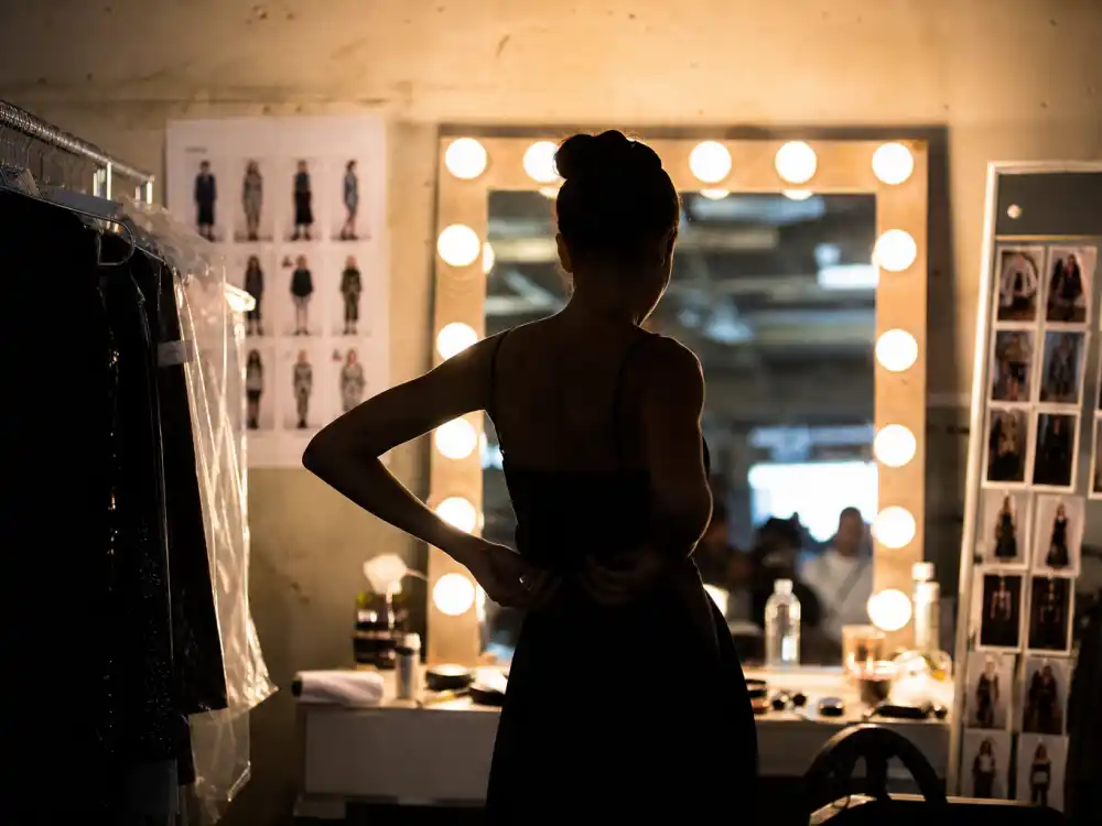Fashion runway backstage mirror for famous celebrity children who are famous now Kaia Gerber modeling tier editorial silhouette without identifiable faces