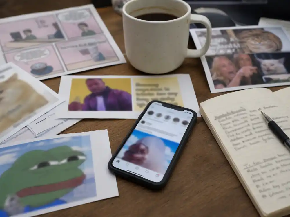Printed meme screenshots on desk for famous viral stars where are they now internet meme culture nostalgia