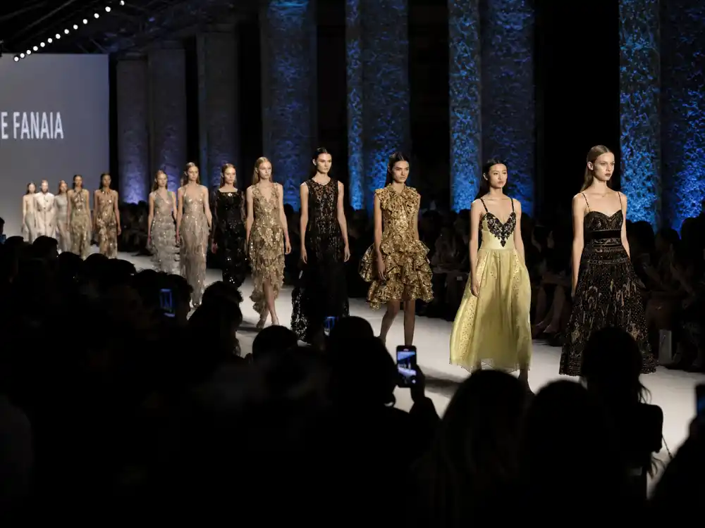 Runway show in progress during fashion week celebrity sightings 2026 season with models on catwalk and anonymous front row silhouettes
