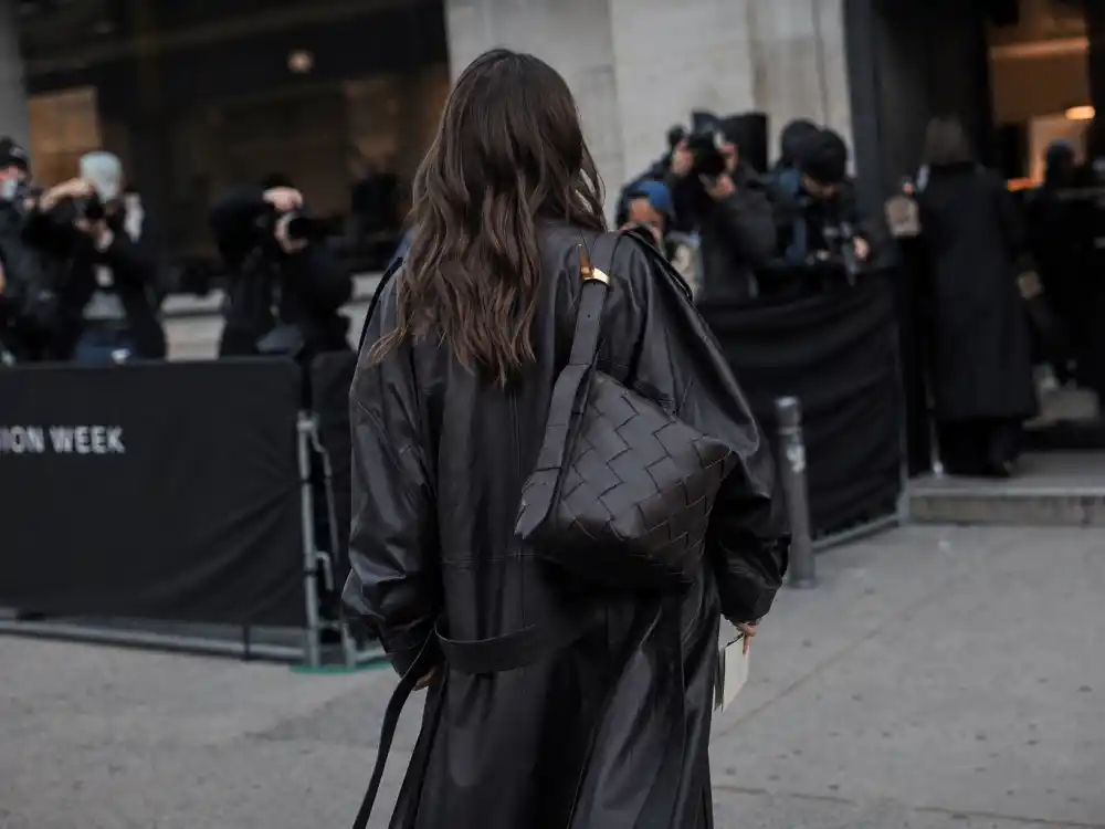 Street style outside fashion week show venue for fashion week celebrity sightings 2026 with anonymous guest photographed from behind near paparazzi