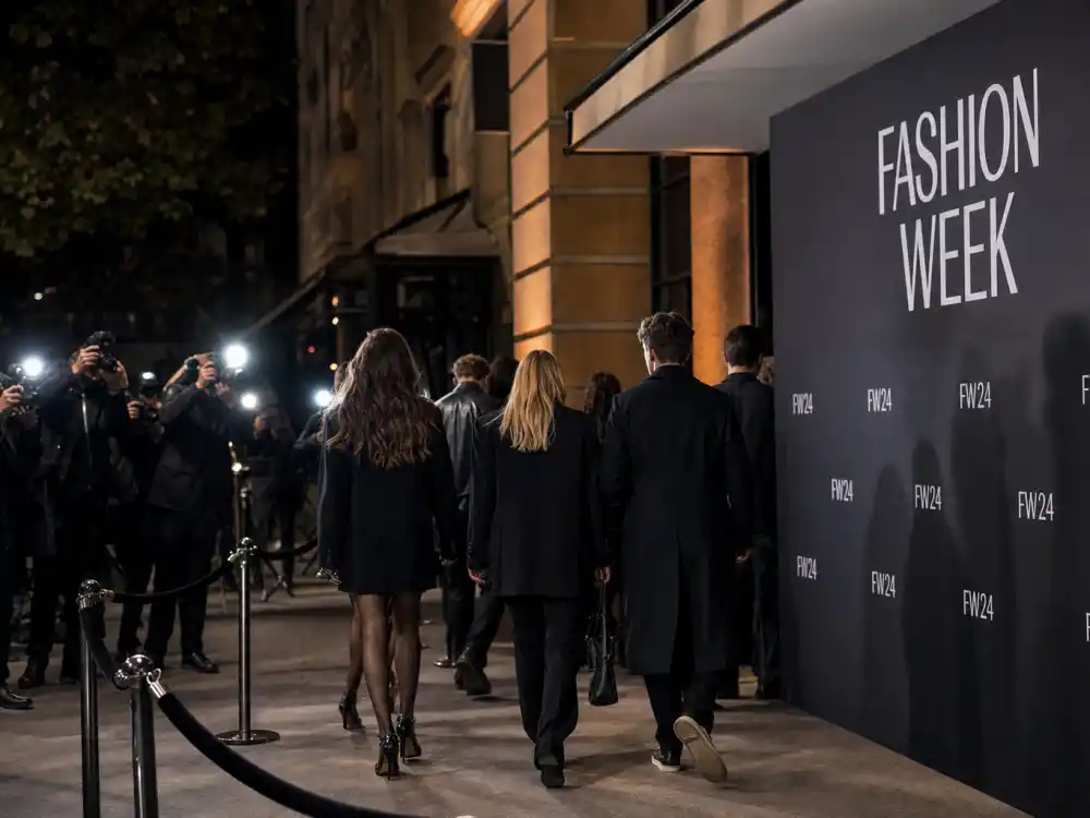 Fashion week show venue exterior with step-and-repeat backdrop for fashion week celebrity sightings 2026 arrivals and red rope entrance