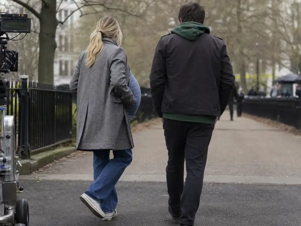 London film set from behind for Florence Pugh pregnancy rumors addressed — prosthetic pregnancy belly prop on We Live in Time shoot not real bump
