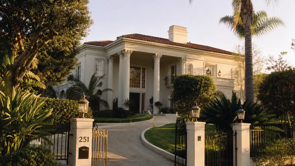 Fresh Prince of Bel Air cast where are they now — upscale Bel-Air mansion exterior with palm trees evoking the iconic NBC sitcom