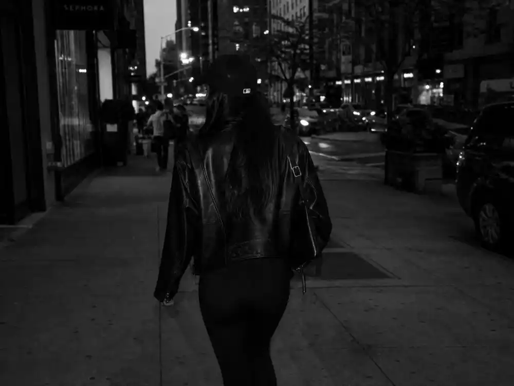 All-black leather jacket leggings and baseball cap behind Gigi Hadid street style 2026 monochrome uniform