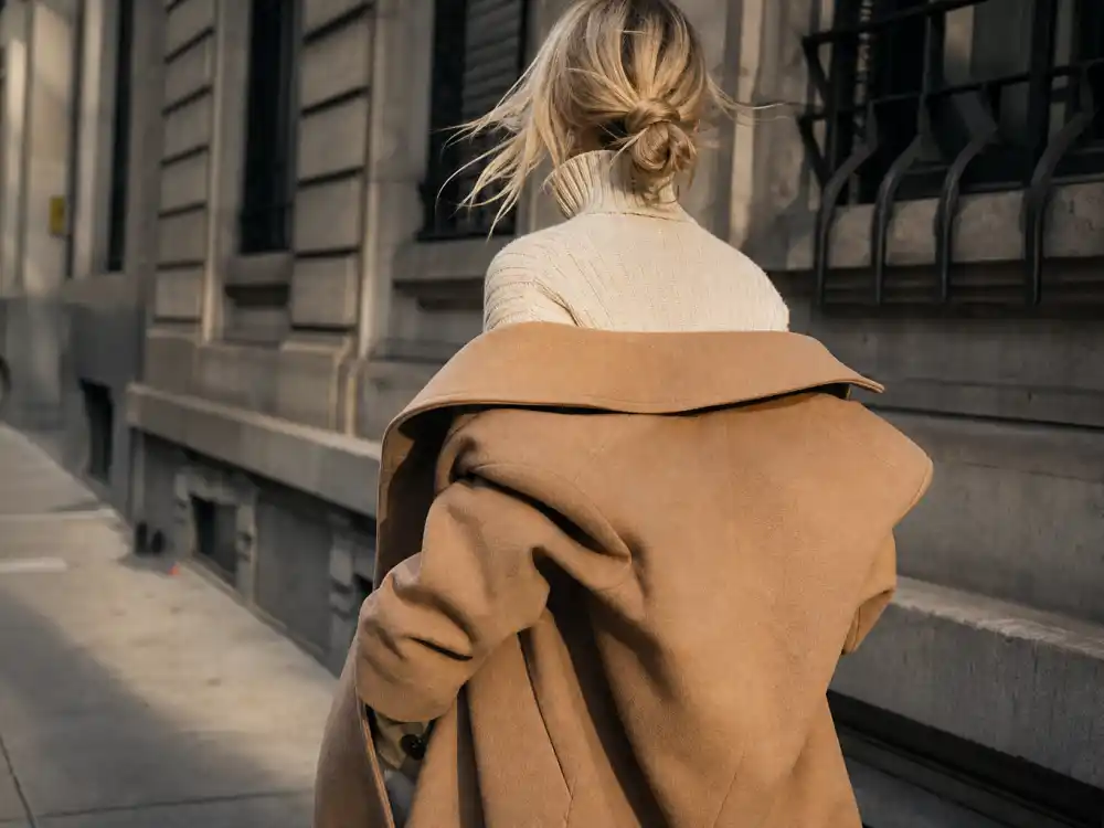 Oversized camel wool coat over cream sweater central to Gigi Hadid street style 2026 outerwear trends