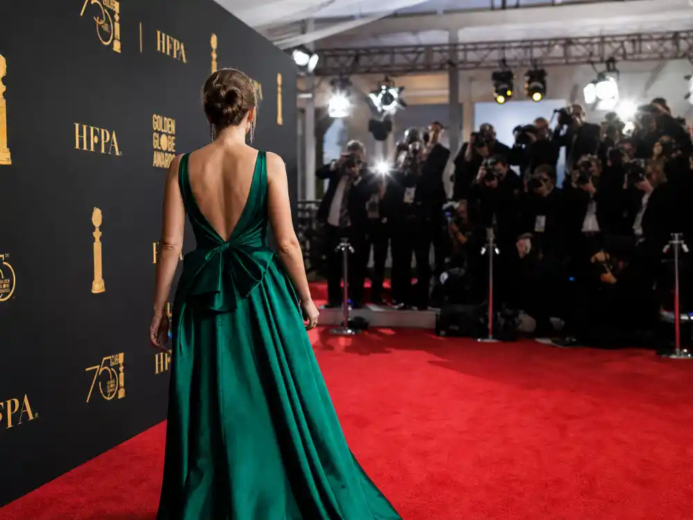 Beverly Hilton Golden Globes best dressed of all time arrival lane with HFPA golden globe logo backdrop and red carpet photographers