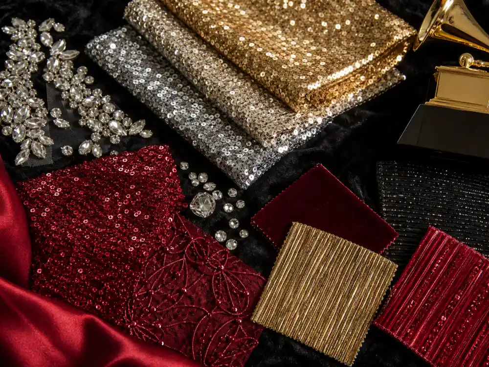 Gold and silver sequin fabric swatches and crystal embellishments flat lay defining grammy awards celebrity outfits 2026 red carpet texture foundation