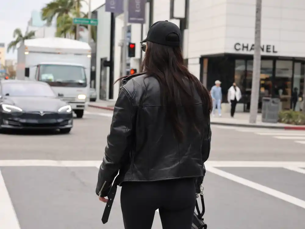 All-black leather jacket leggings and baseball cap behind Hailey Bieber street style looks monochrome uniform