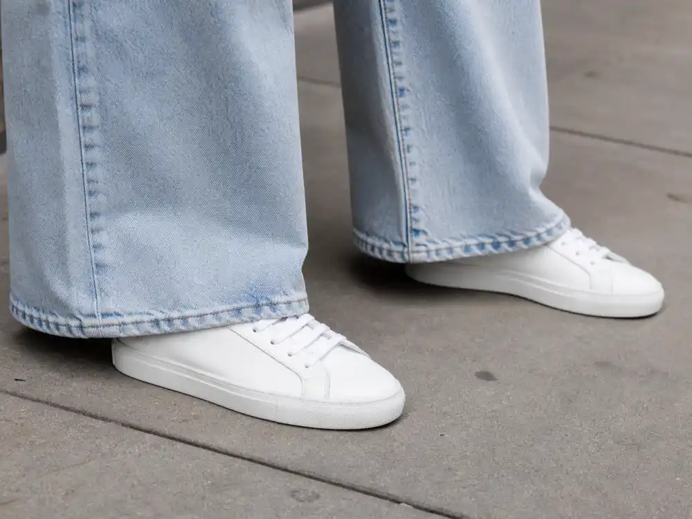 Pristine white sneakers with wide-leg jeans showing Hailey Bieber street style looks elevated footwear codes