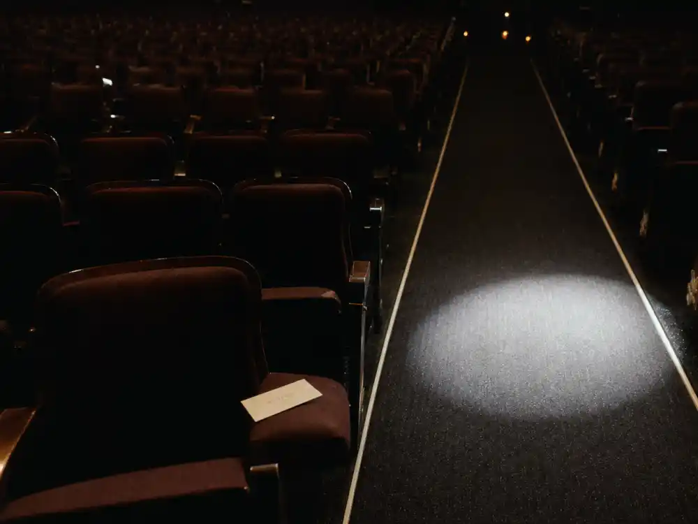 An awards-show spotlight on empty seats symbolizing the early Oscar-nominee fame of Haley Joel Osment