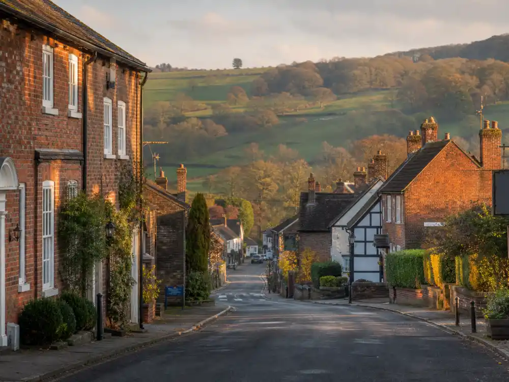 English village high street evoking Harry Styles age and birthday 2026 upbringing — the Cheshire countryside where he grew up in Holmes Chapel after his Redditch birth