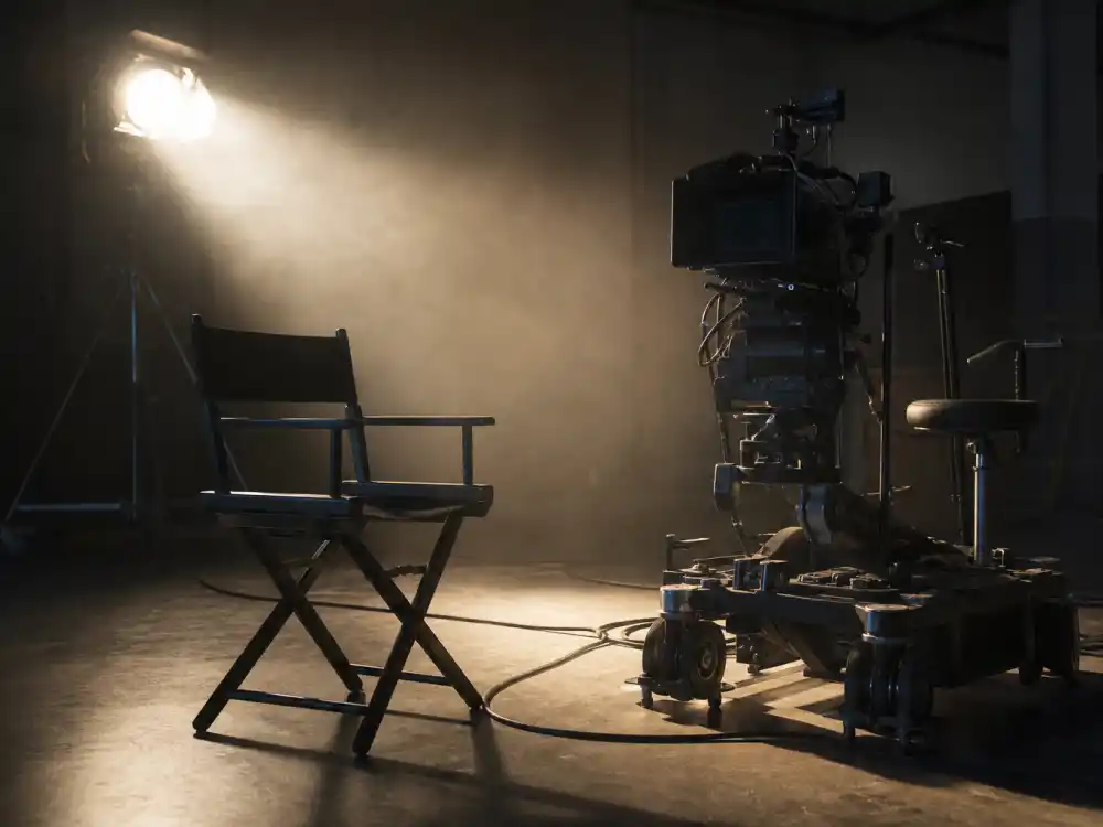 A darkened film set with a camera and director chair, representing the Hayden Christensen Star Wars return