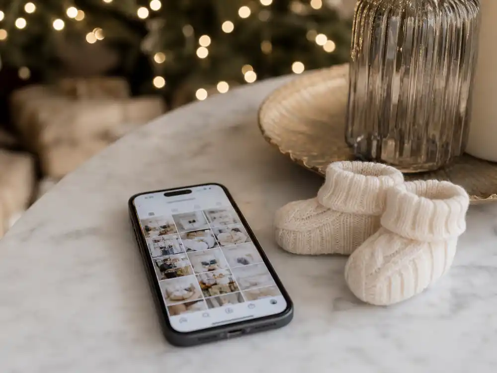 Phone beside tiny booties for Hilary Duff baby number four announcement Instagram reveal fans recognized in December 2023