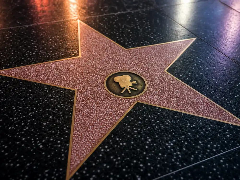 Motion Pictures category stars on the Hollywood Walk of Fame 2026 honorees list — brass camera emblem terrazzo markers on Hollywood Boulevard