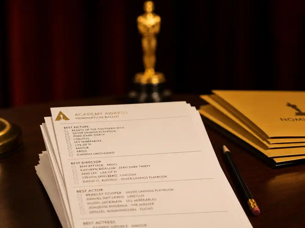 Academy paper ballots on a desk illustrating how are Oscar winners chosen voting explained through member-marked nomination forms