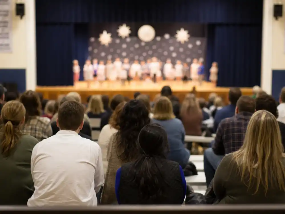 School event auditorium from behind for how celebrity exes co-parent peacefully joint attendance editorial without identifiable faces