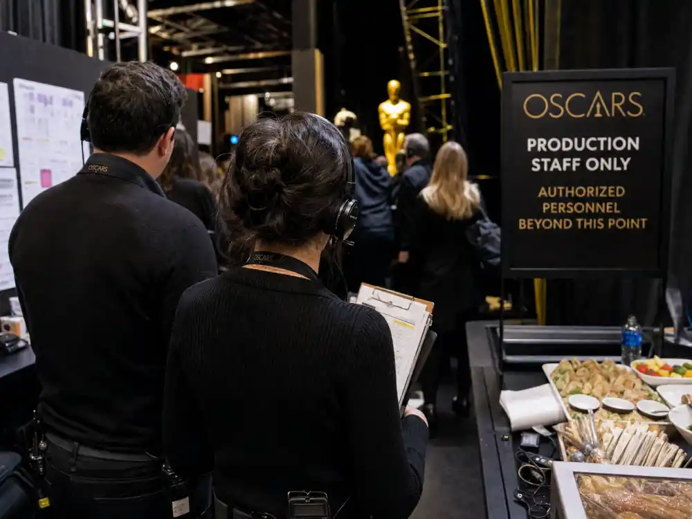 Backstage production crew with headsets and call sheets for how much do the Oscars cost to produce staffing and labor on Oscar Sunday