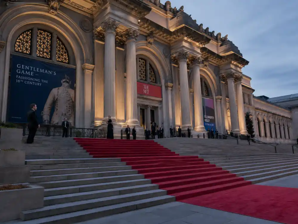 Metropolitan Museum grand staircase with red carpet — how much does it cost to attend award shows when Met Gala table donations reach six figures