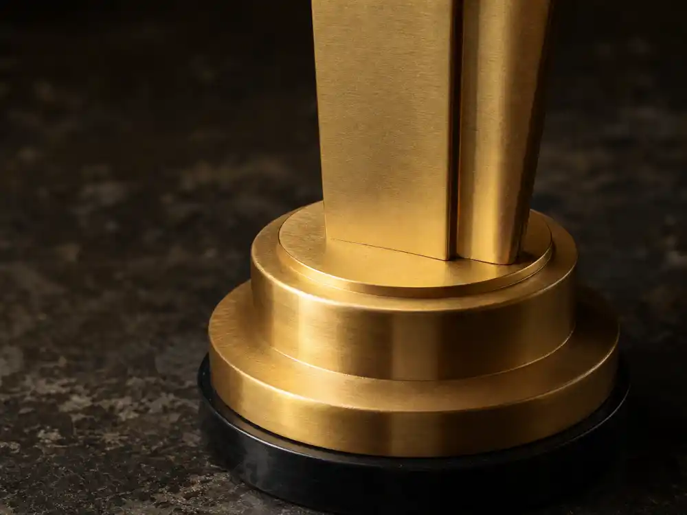 Close detail of gold-plated generic statuette base — raw materials behind how much is an Oscar statue worth in metal alone