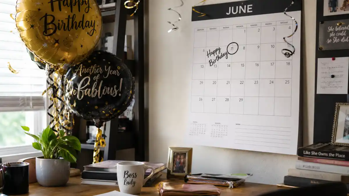 How old is Angelina Jolie — desk calendar open to June with birthday decorations marking her Gemini birth date