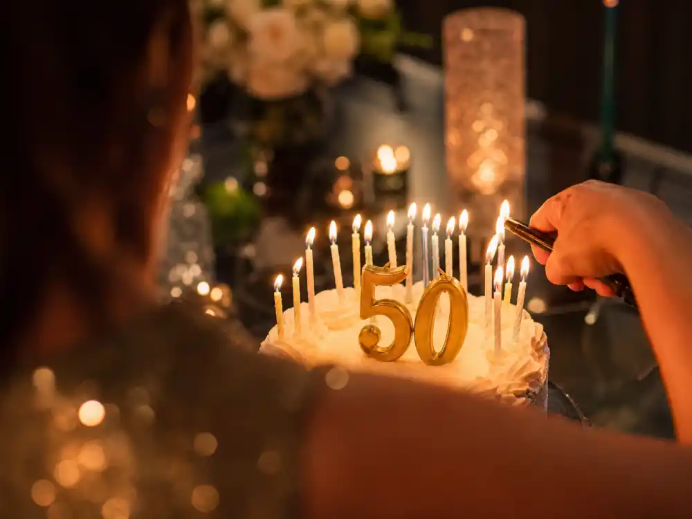 Birthday cake candles from behind for how old is Beyonce age milestone editorial without identifiable faces
