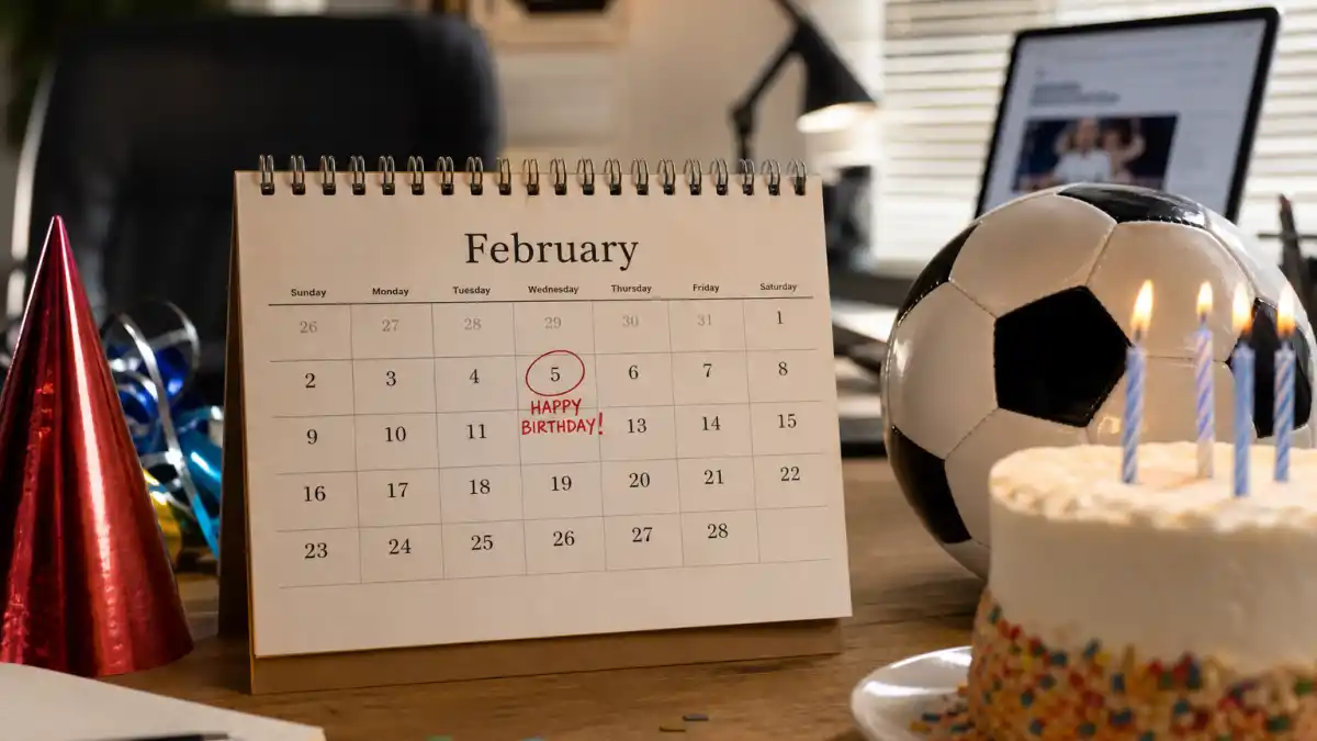 How old is Cristiano Ronaldo — desk calendar open to February with birthday decorations and soccer ball marking his Aquarius birth date