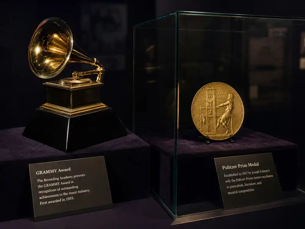 Grammy and Pulitzer award display reflecting how old is Kendrick Lamar at industry peak — chart-topping albums and historic Pulitzer Prize win in his late twenties