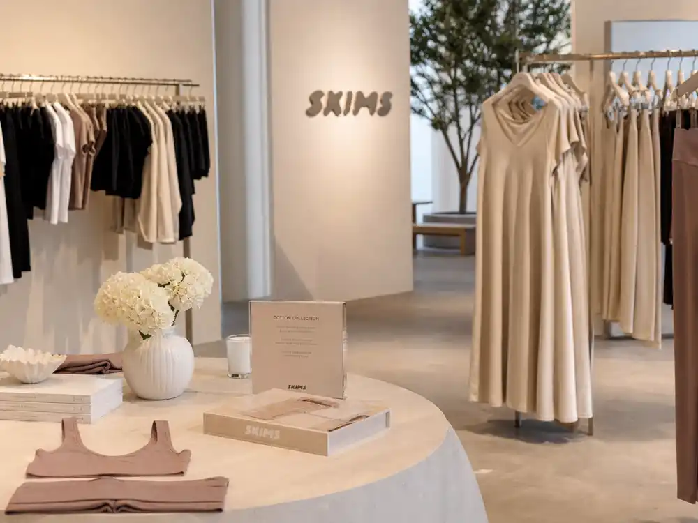 Fashion boutique interior reflecting how old is Kim Kardashian at industry peak — business empire status across beauty, shapewear, and media in her mid-forties