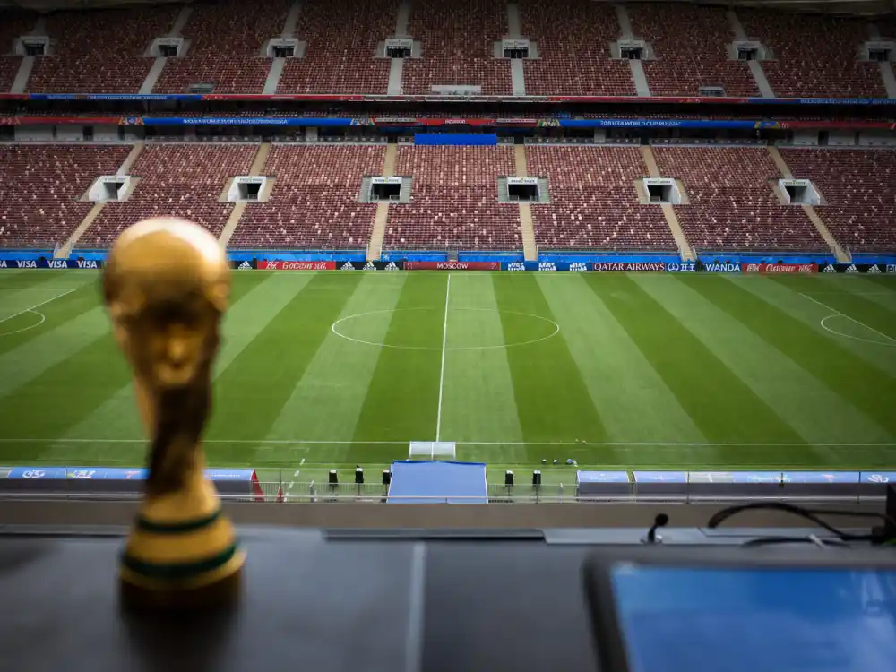 Soccer stadium interior reflecting how old is Kylian Mbappe at career peak — 2018 World Cup triumph at age nineteen and Golden Boot run at Qatar 2022